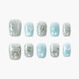 Blue and white handmade press-on nails with floral design and pearl accents, arranged on white background