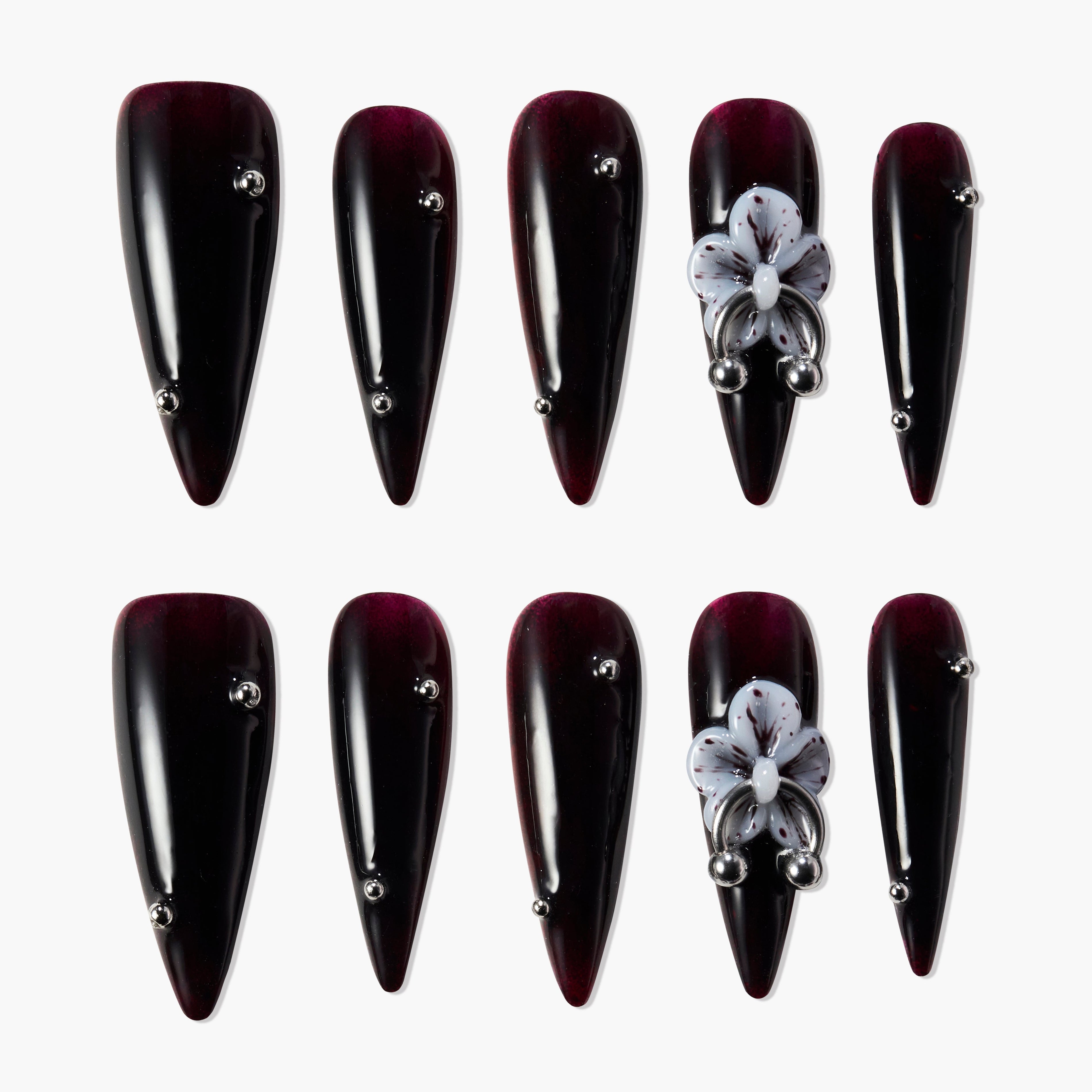 Glossy dark burgundy press-on nails with metallic studs and 3D purple floral accent design