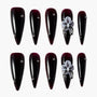 Glossy dark burgundy press-on nails with metallic studs and 3D purple floral accent design