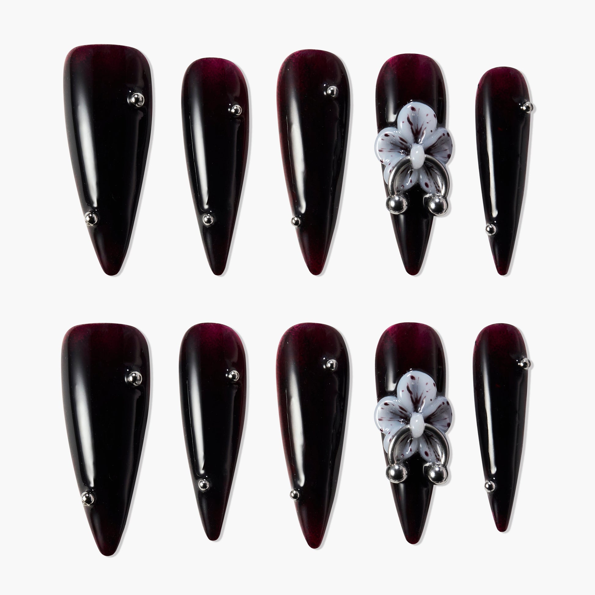 Glossy dark burgundy press-on nails with metallic studs and 3D purple floral accent design