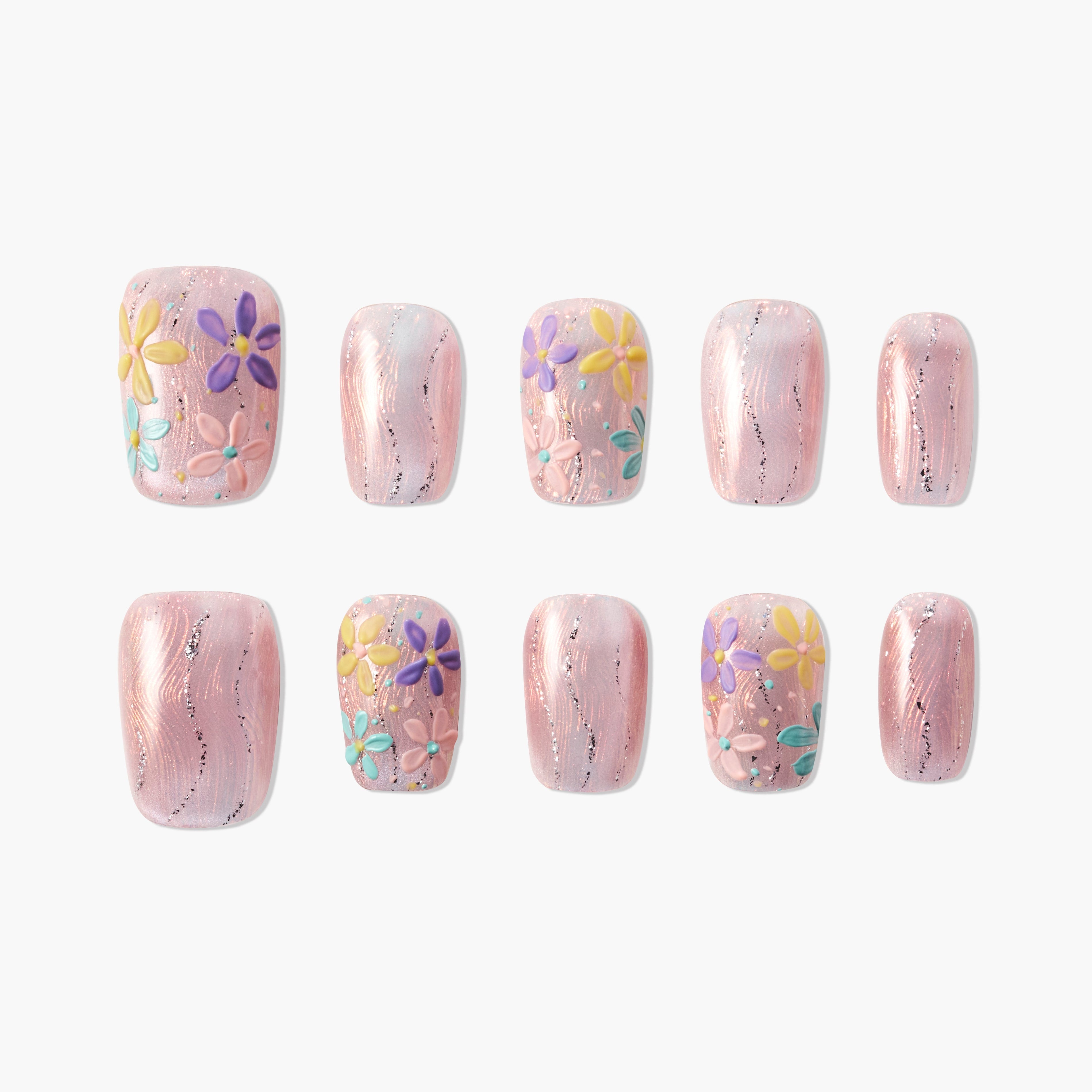 Handmade press-on nails with pink shimmer and 3D floral designs in yellow, purple, and teal.