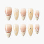 Handmade press-on nails with pearl, rhinestone, and gold glitter designs in nude tones
