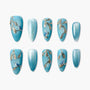 Blue press-on nails with glitter branches and small bird designs, elegant and reusable.