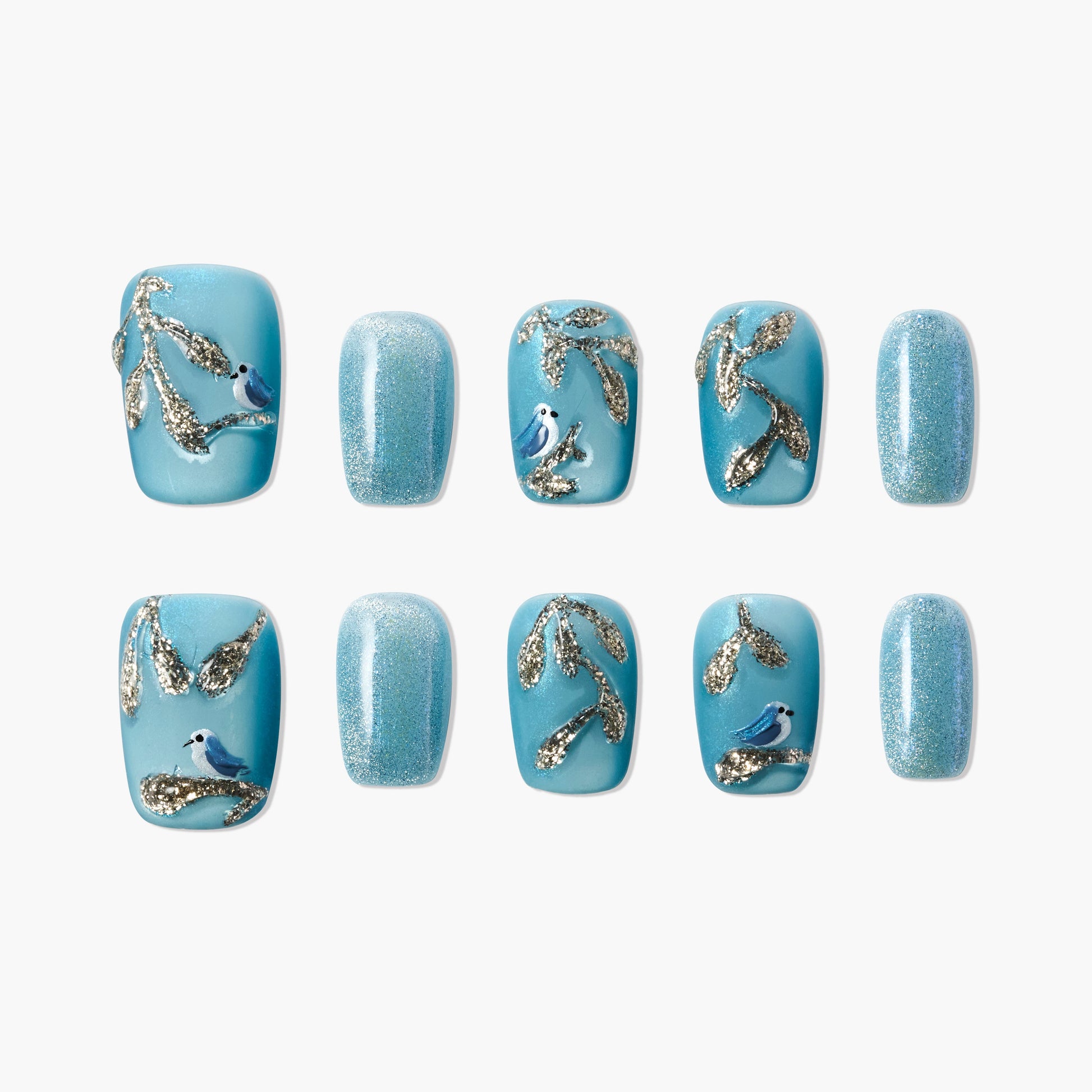 Blue press-on nails with glitter, gold branch designs, and bird accents on white background