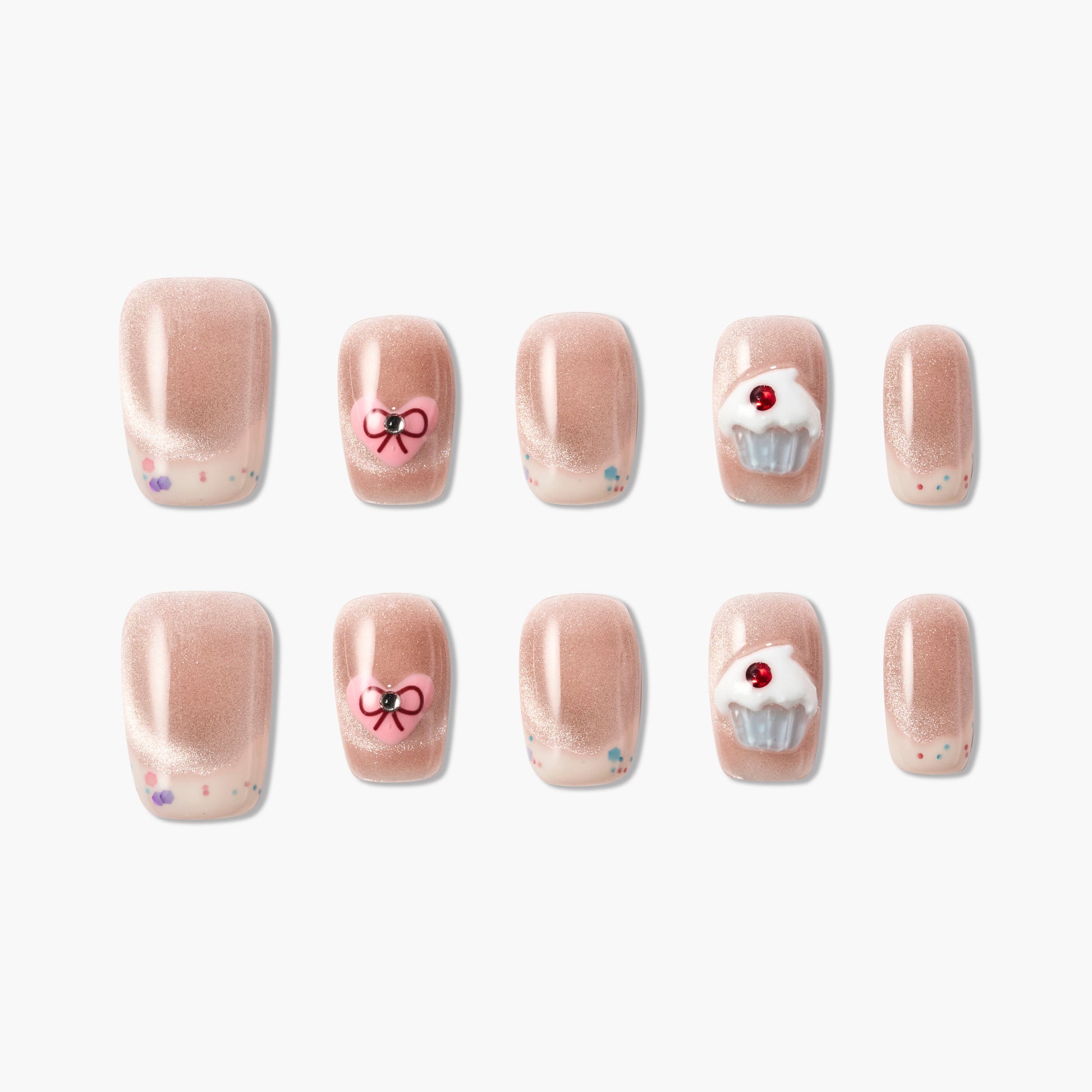 Handmade press-on nails in nude pink with 3D bow, cupcake, and confetti designs.