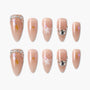 Handmade nude press-on nails with floral designs, gold foil, and rhinestone accents