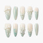 Handmade press-on nails with pastel green ombré, pearl accents, bows and 3D floral designs