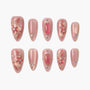 Handmade pink press-on nails with gold floral designs, crystals, and pearl accents