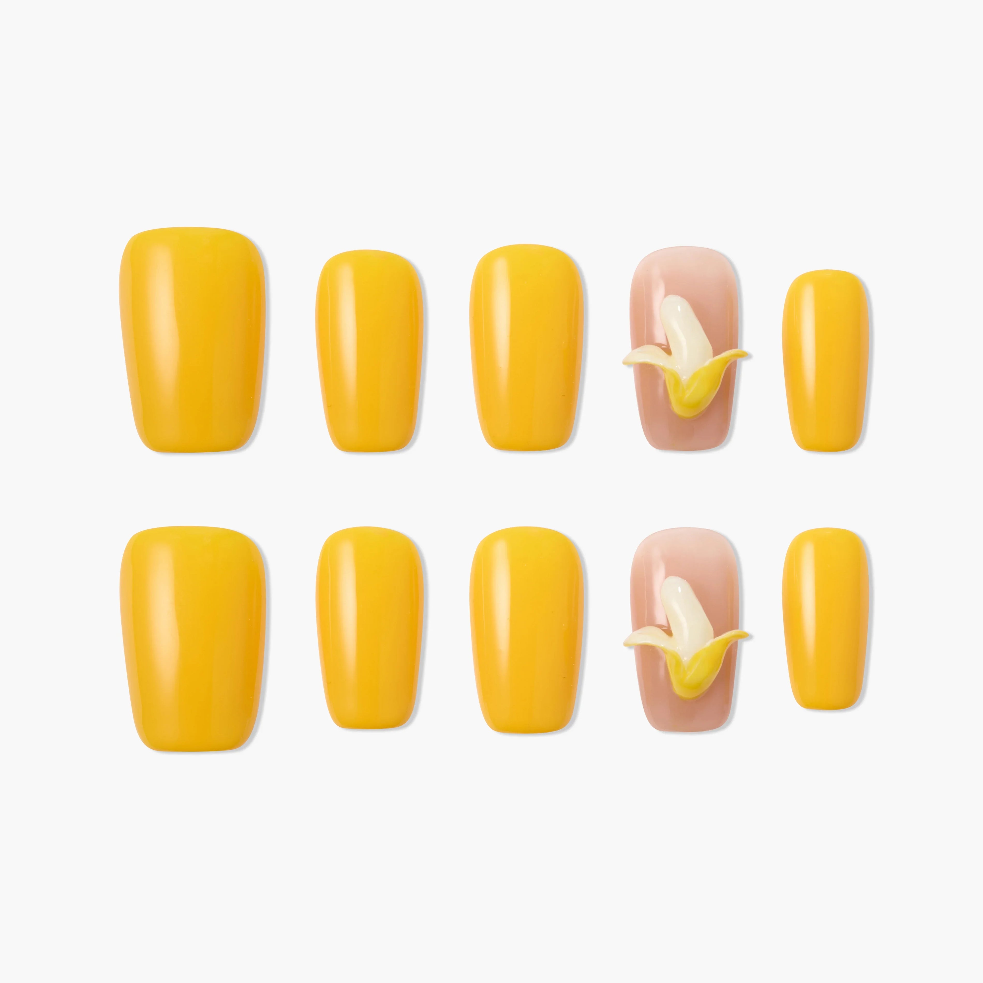 Yellow press-on nails set with two nude nails featuring 3D banana fruit design, displayed on white background.