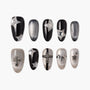 Black and silver press-on nails with 3D stars and cross charms, glittery and bold nail art design
