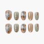 Handmade press-on nails with marble patterns, sage green, gold metallic accents, and artistic designs