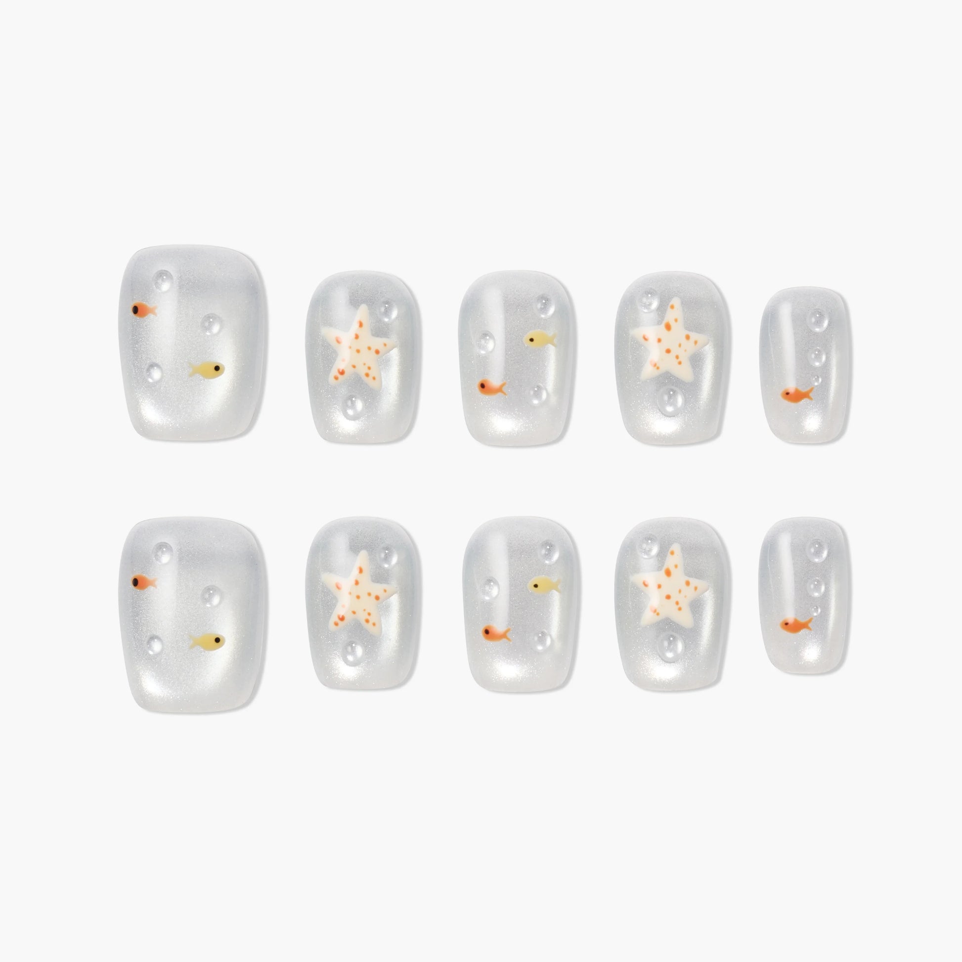 Handmade press-on nails with starfish and fish designs on a pearly white background