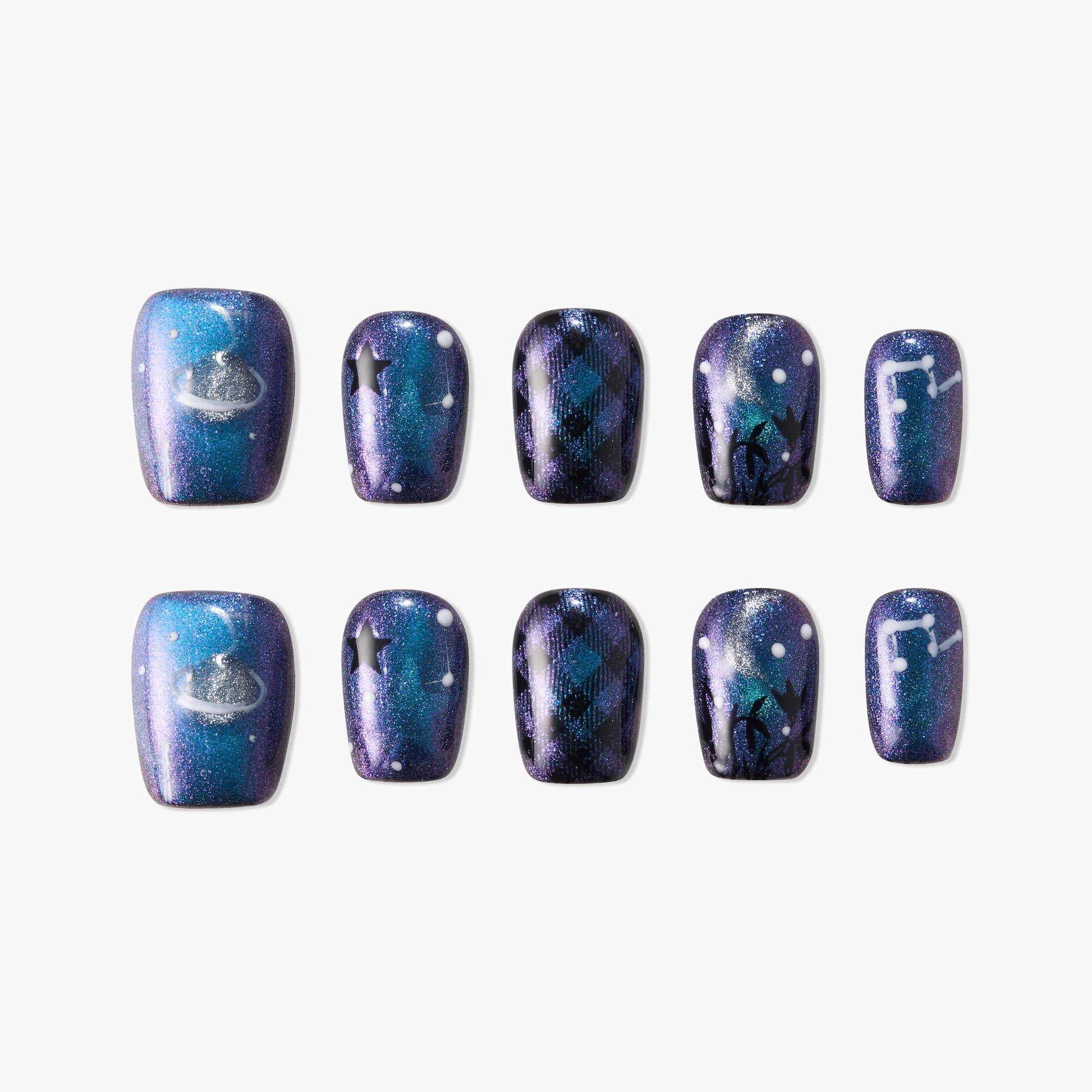 Galaxy-themed press-on nails with blue and purple shimmer, stars, plaid, and constellation designs