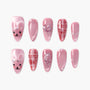 Pink press-on nails with bear faces, glitter, heart, moon, and plaid designs.
