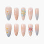 Floral press-on nails with pastel designs, pearl accents, and gradient nude to blue tips