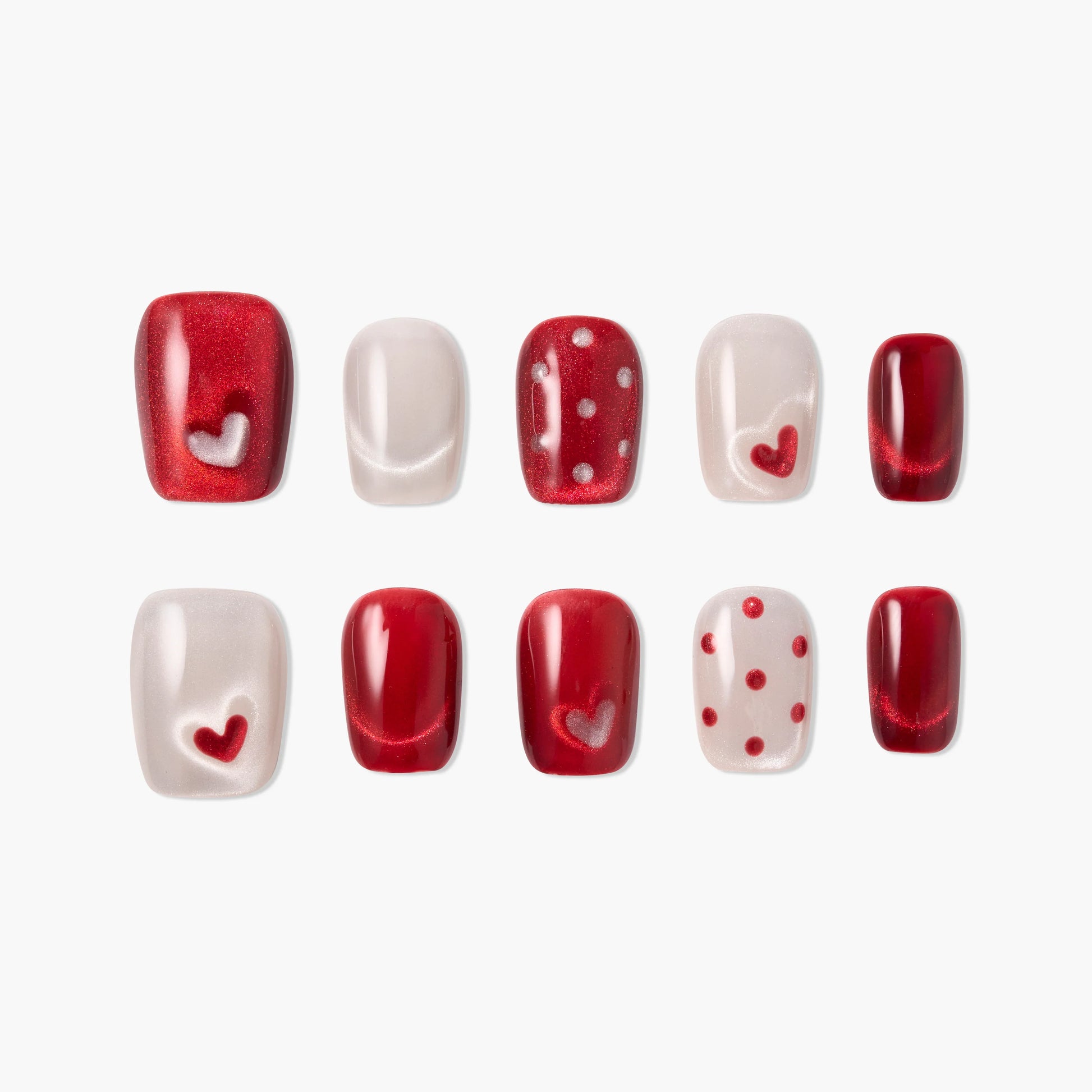 Handmade press-on nails in red and pearl with heart and polka dot designs, glossy finish