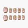 Handmade press-on nails with pink and gold glitter design, arranged on a white background.