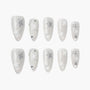 White press-on nails with silver glitter star designs, pearl finish, and rhinestone accents.