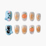 Handmade press-on nails set with cartoon faces, peach accents, and blue polka dot design.