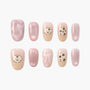 Handmade press-on nails with pastel pink designs, cute dog faces, bows, and star patterns