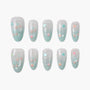 Handmade press-on nails with pastel blue tips, star decals, and pink bead accents