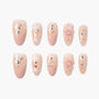 Handmade press-on nails in nude pink with glitter, white accents, and 3D floral design