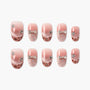 Pink ombre press-on nails with rhinestones, bows, and glitter accents, arranged in a set.