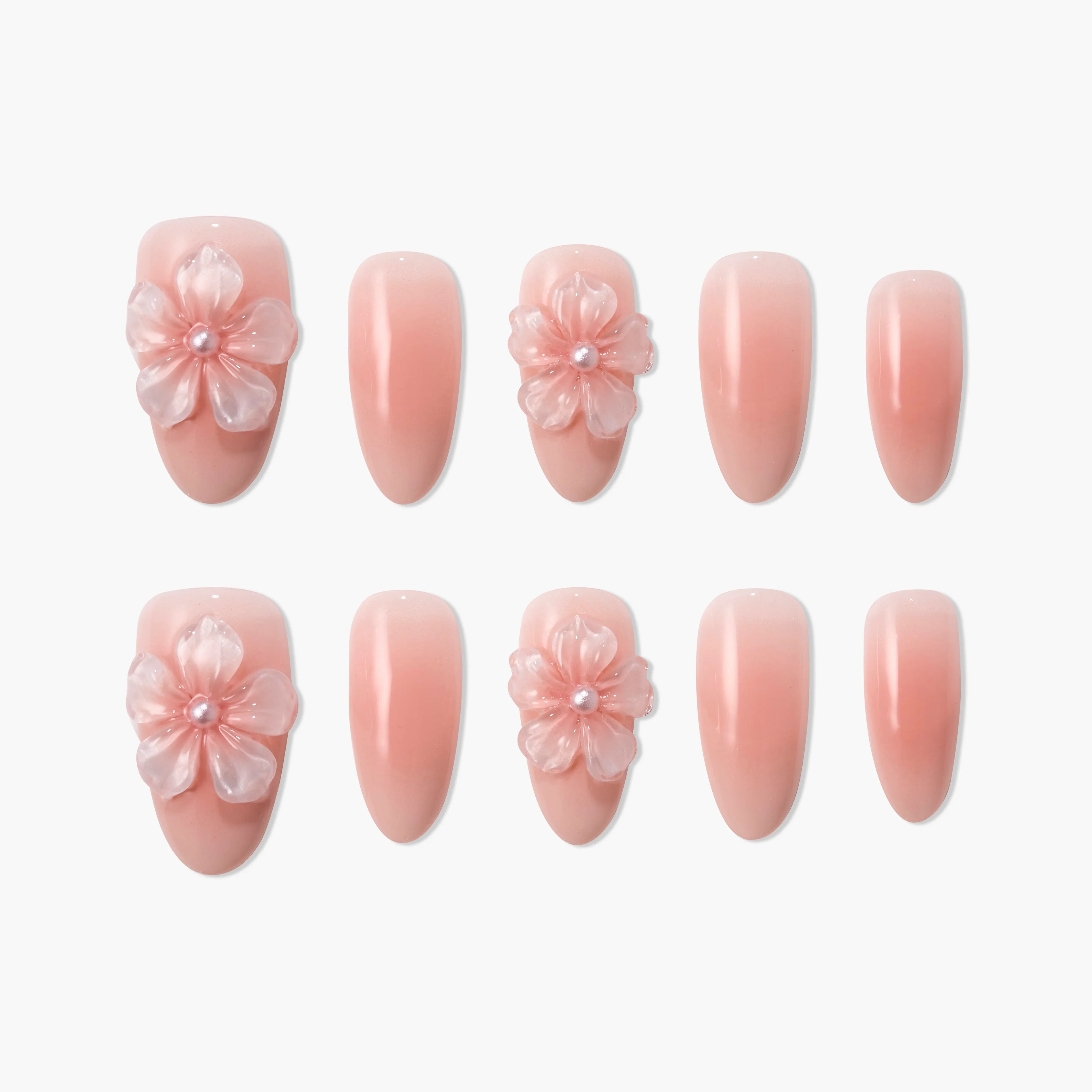 Set of pink press-on nails with 3D floral accents and glossy finish, arranged on white background.