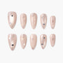 Nude press-on nails with silver glitter and star accents, arranged on white background