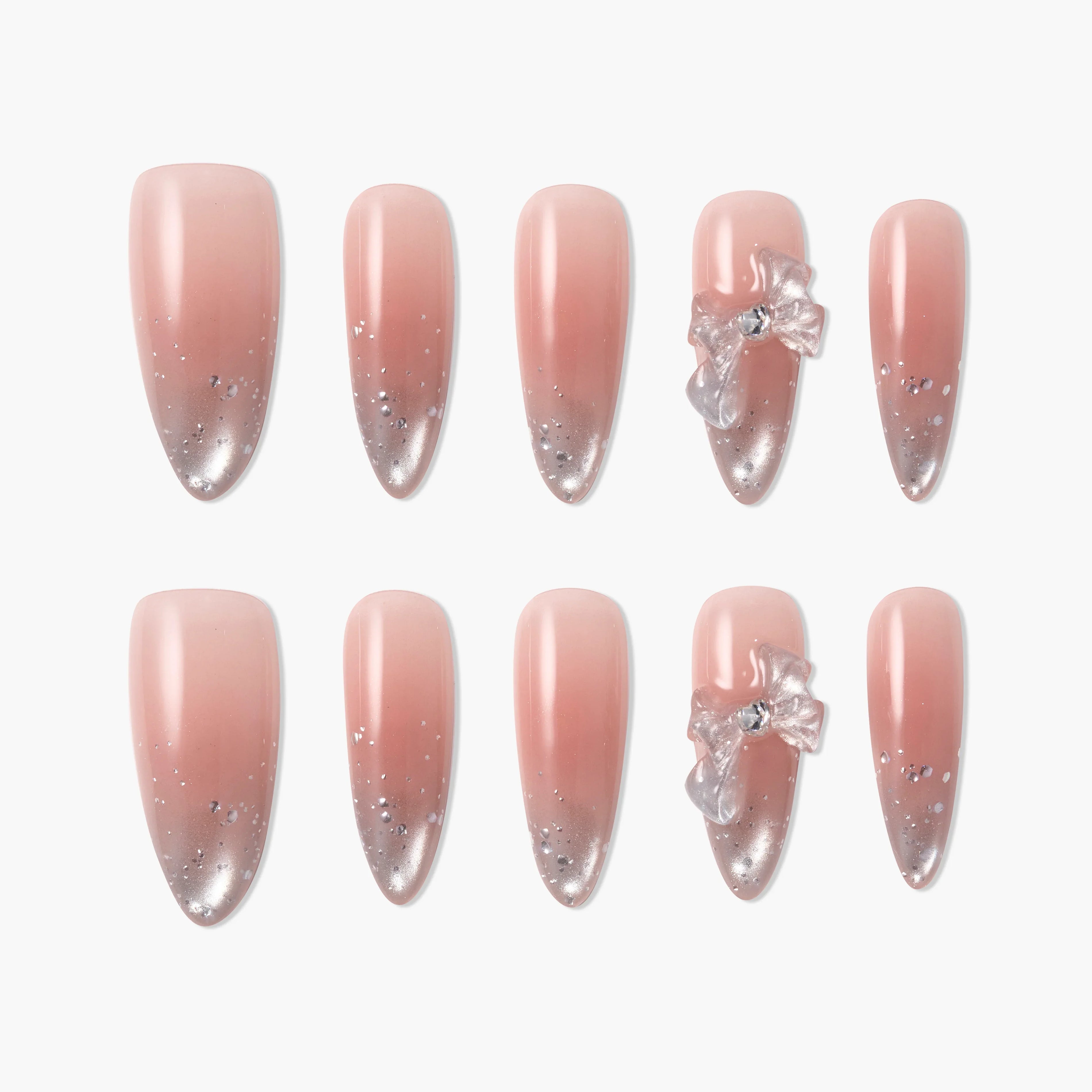 Pink ombre press-on nails with silver glitter and 3D bow accents, displayed on white background