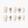 Pearl white press-on nails with 3D jeweled floral and beaded accents, arranged on white background.