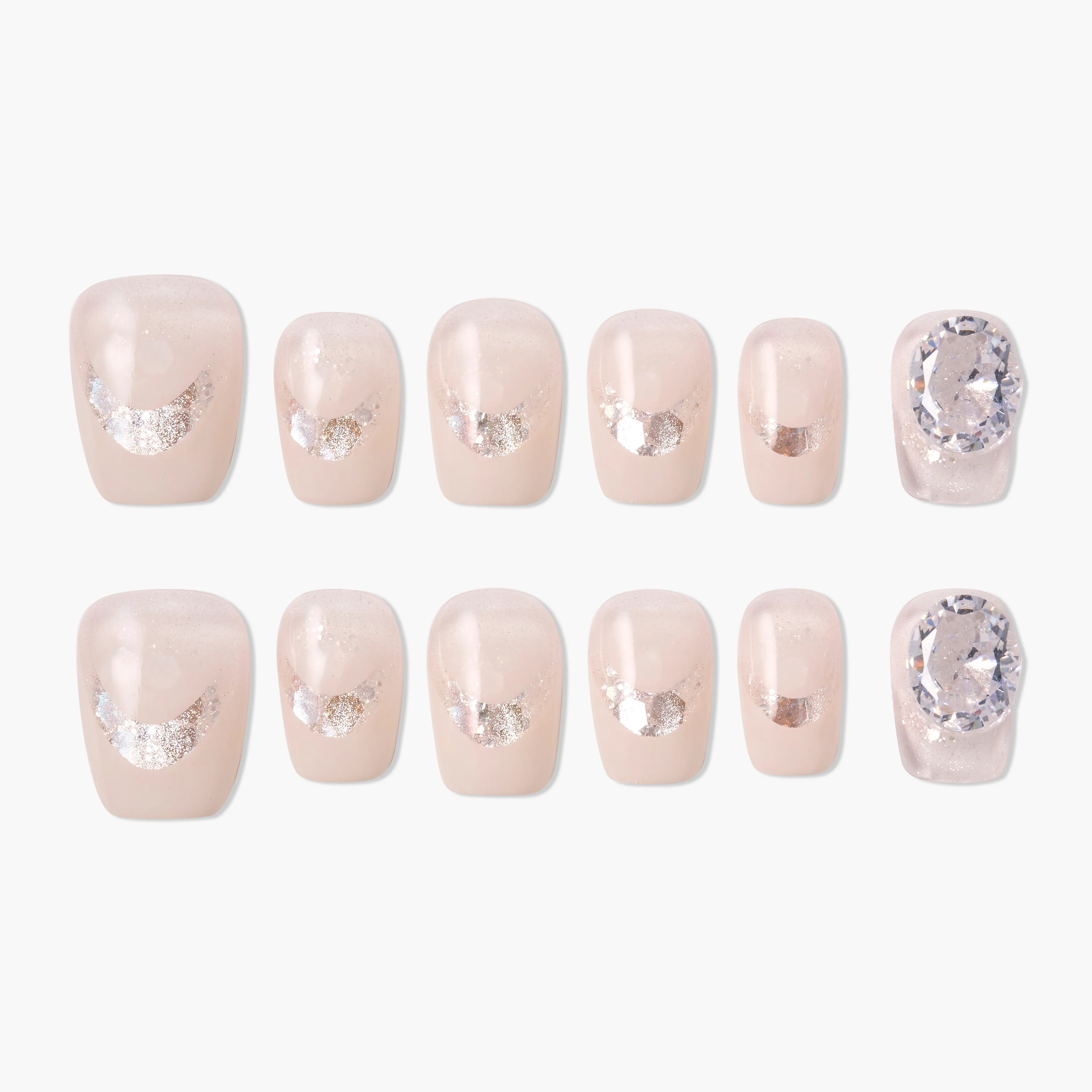 Set of nude press-on nails with silver glitter accents and large crystal embellishments