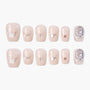 Set of nude press-on nails with silver glitter accents and large crystal embellishments