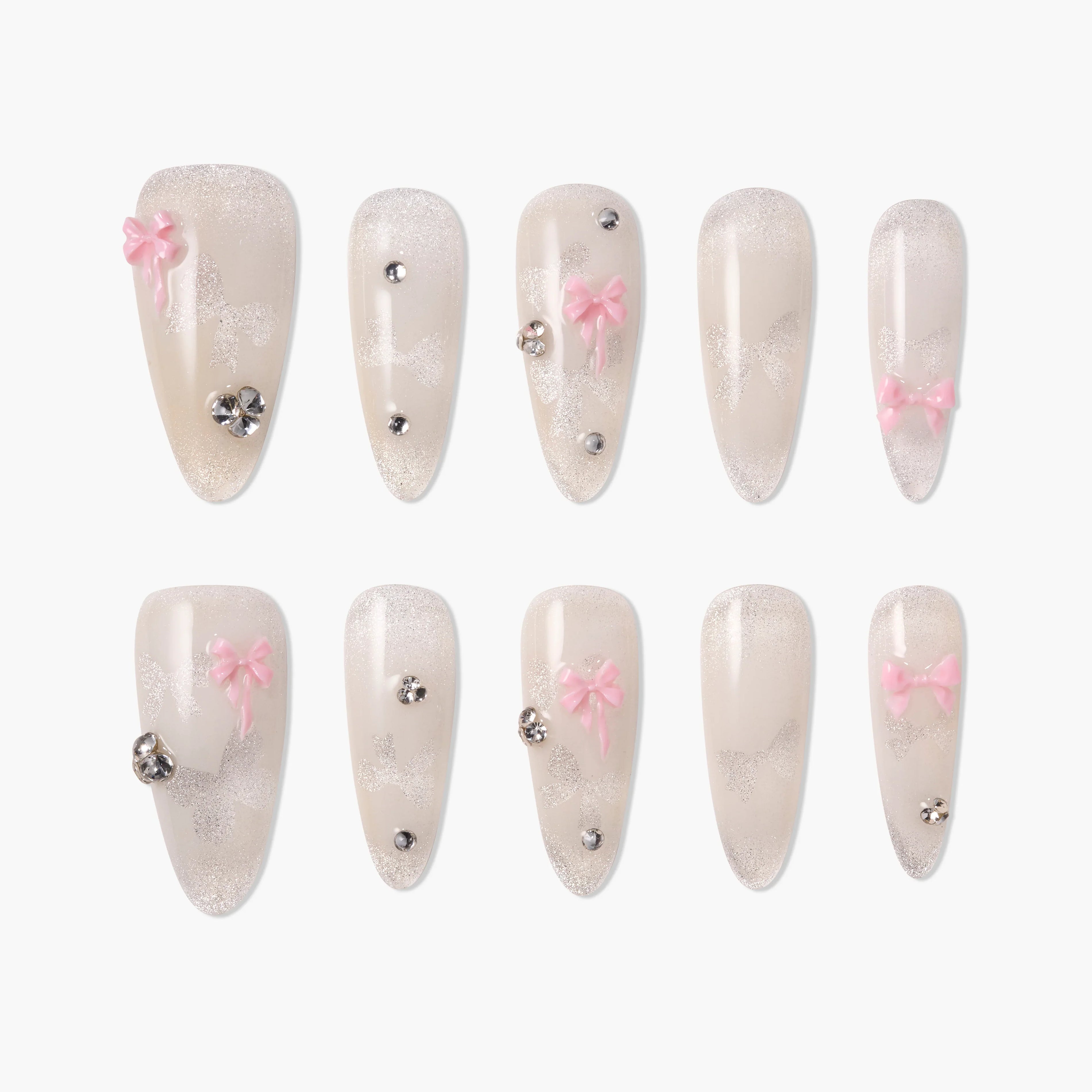Handmade press-on nails with pale glitter, pink bows, and rhinestone accents, arranged in two rows