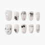 Cute white and silver press-on nails with black bows, stars, pearls, and 3D bunny design.