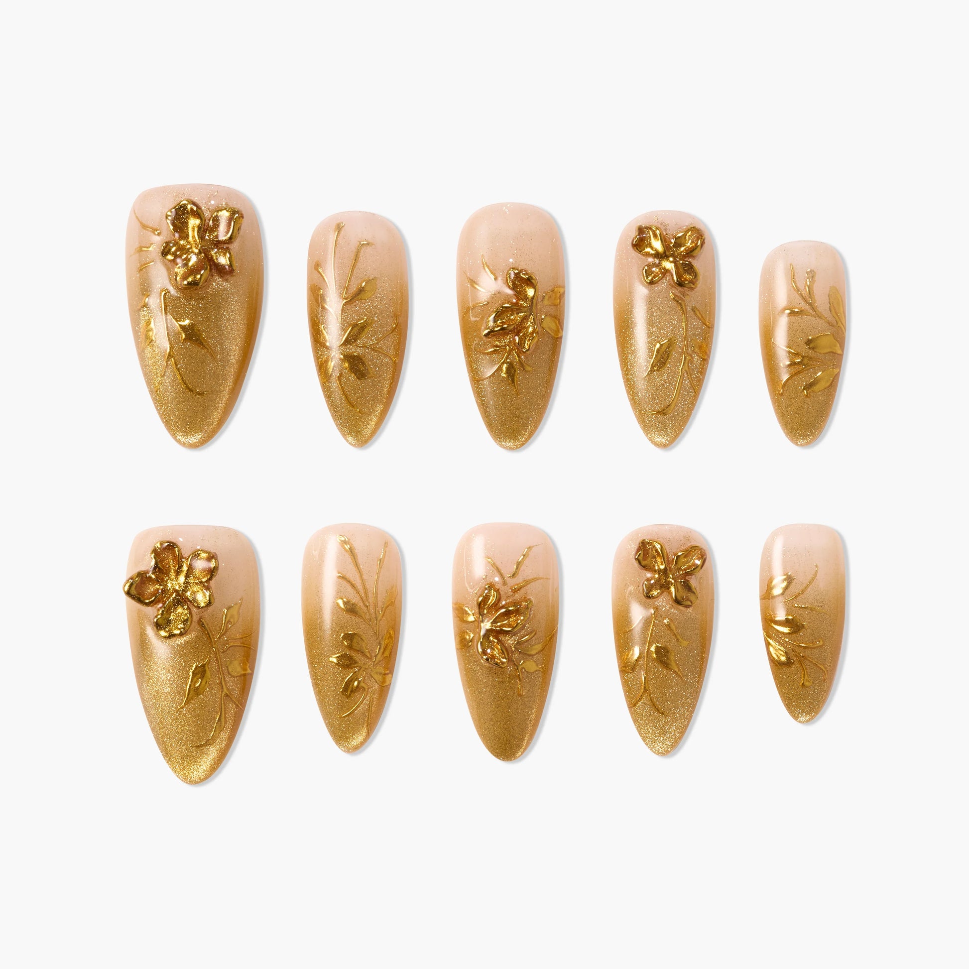 Gold floral press-on nails with 3D flower designs on nude gradient background, arranged in two rows.