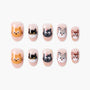 Handmade press-on nails with cute cat, dog, and mouse cartoon faces on a nude background