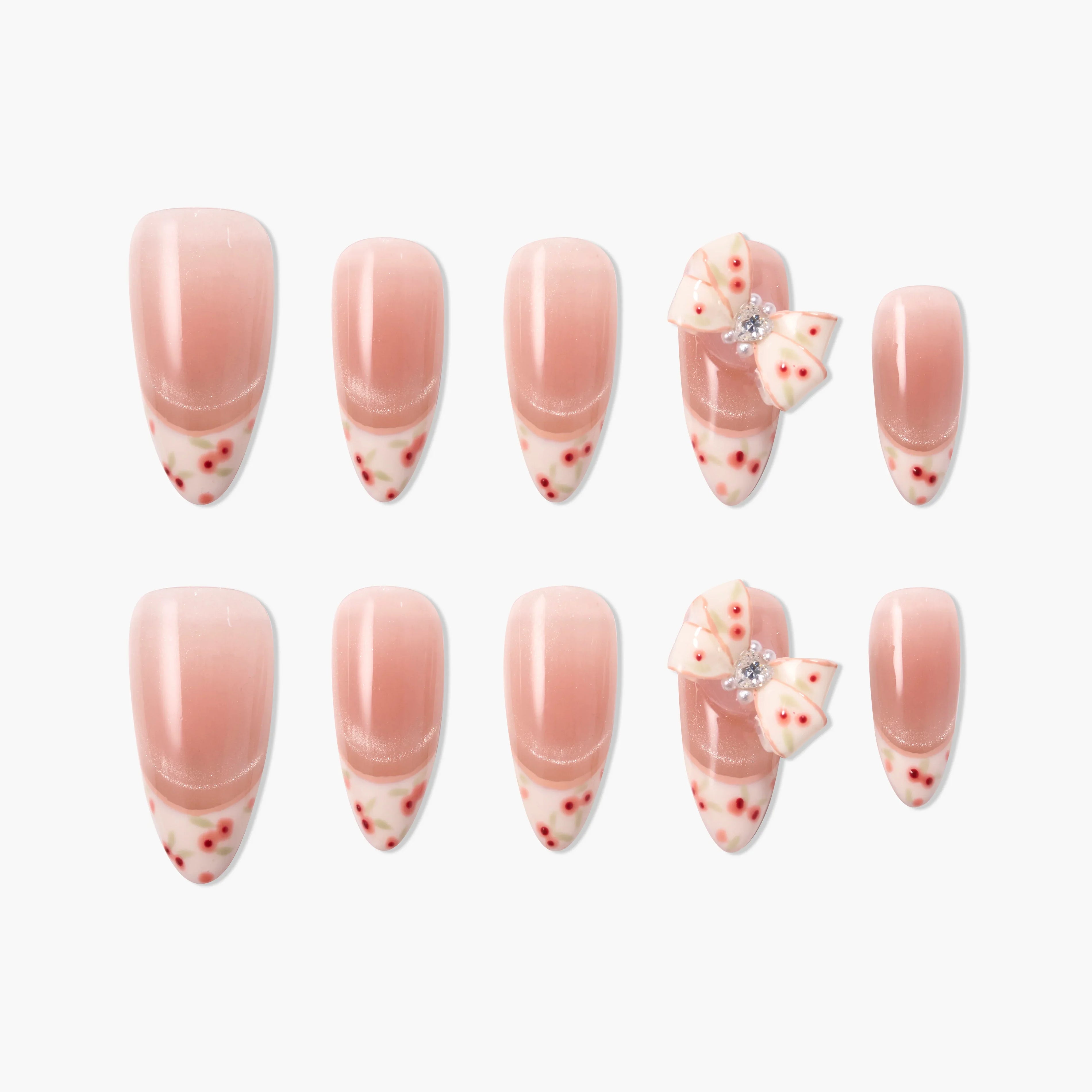 Handmade press-on nails with pink ombre, floral tips, and 3D bow accents, set on white background.