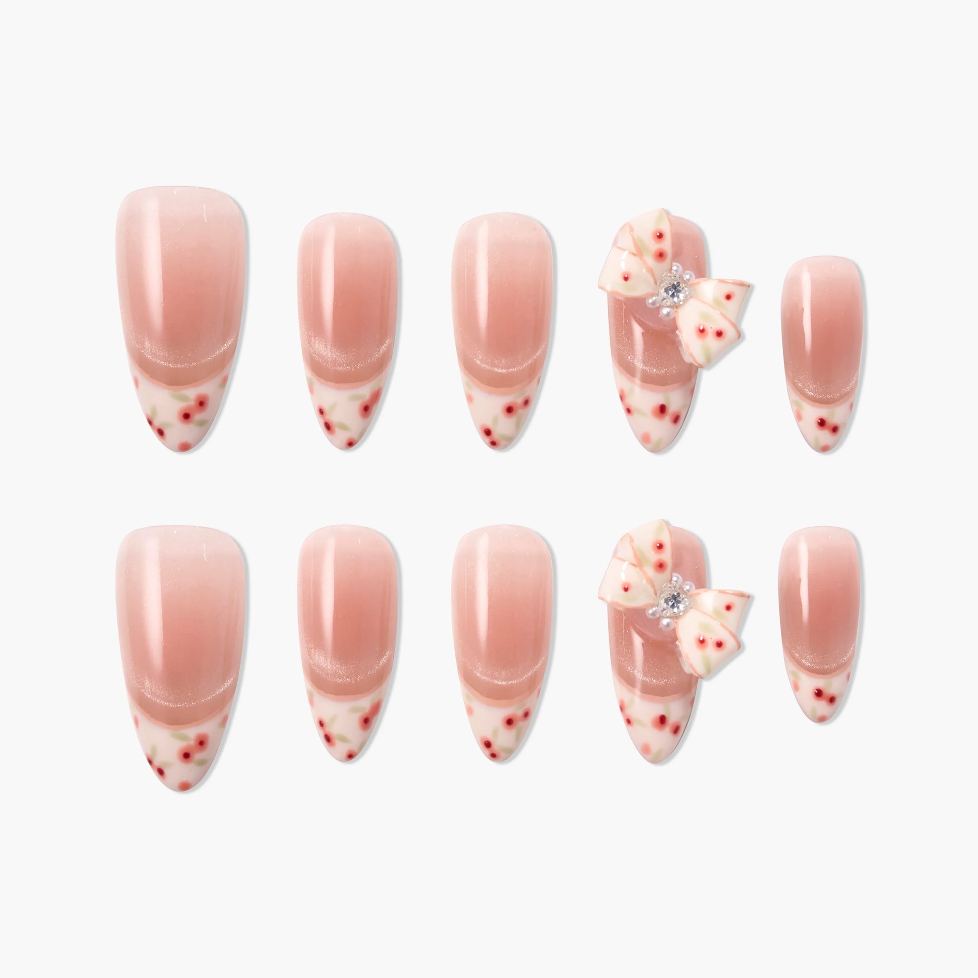Handmade press-on nails with pink ombre, floral tips, and 3D bow accents, set on white background.