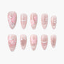 Handmade press-on nails with pink floral and bow designs on a glittery nude background