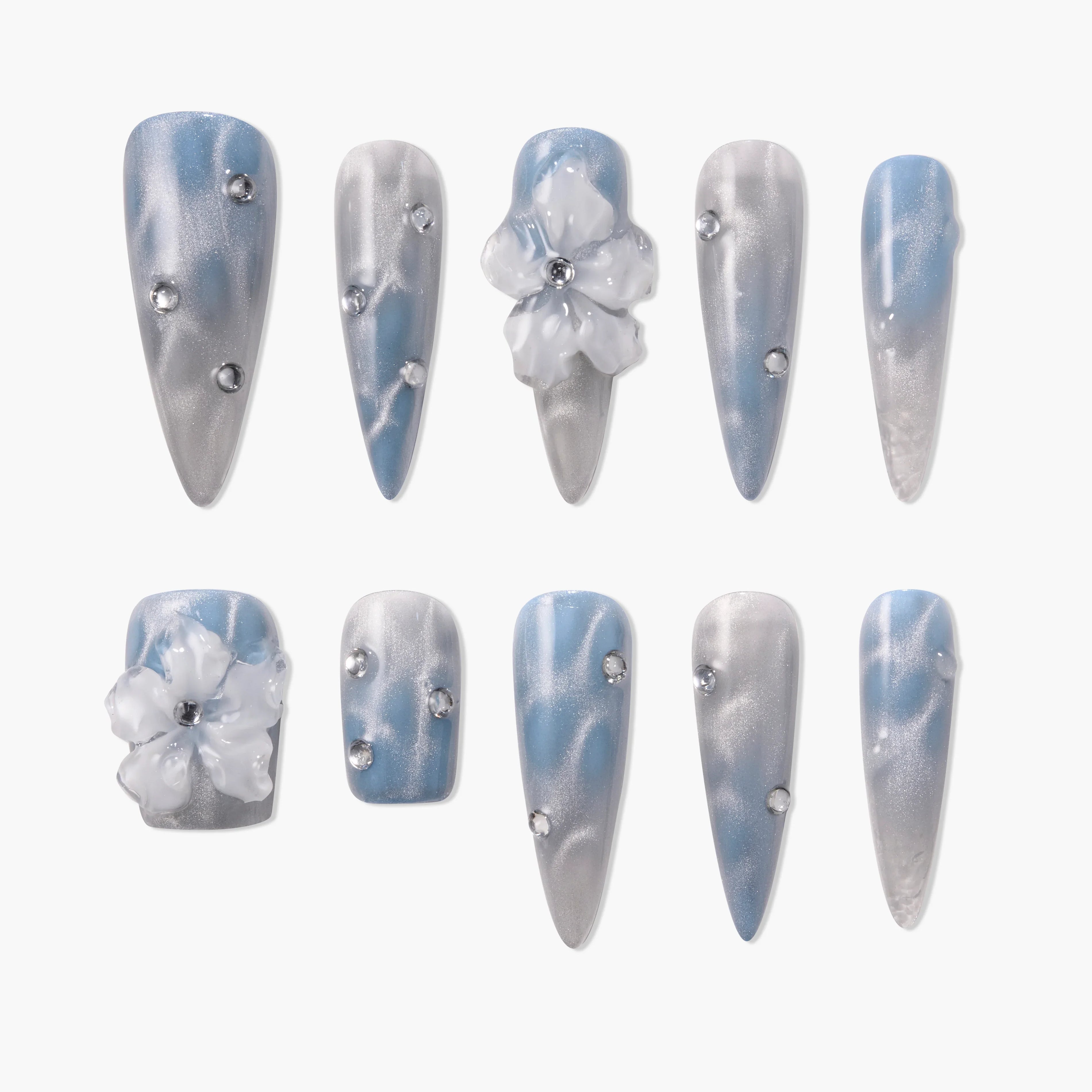 Blue and silver press-on nails with rhinestones and 3D floral accents, glossy finish.
