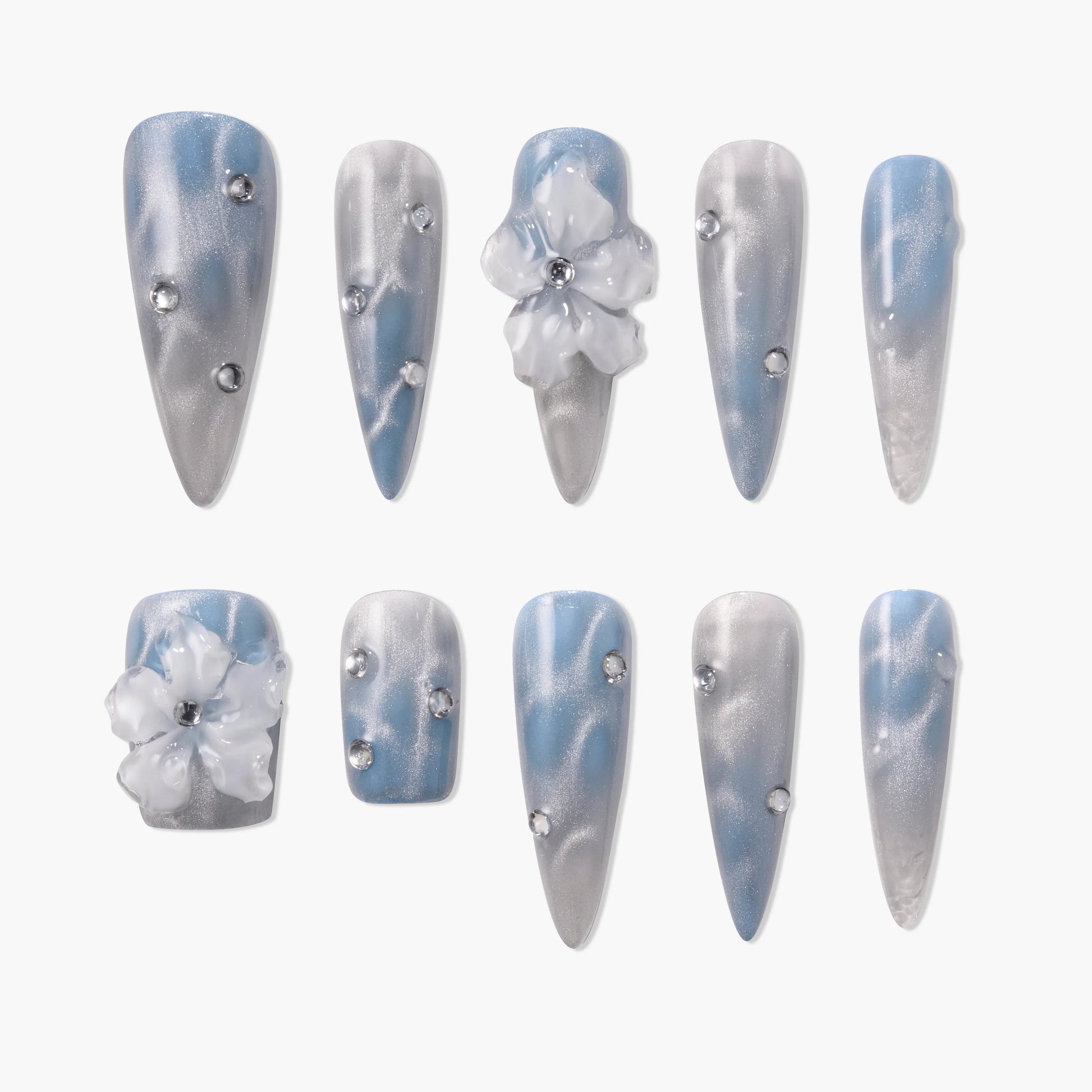 Blue and silver press-on nails with rhinestones and 3D floral accents, glossy finish.