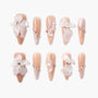 Handmade nude press-on nails with 3D white flower accents and pearl embellishments