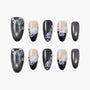 Handmade press-on nails with black, silver, and nude tones, featuring 3D floral and rose designs with rhinestones.