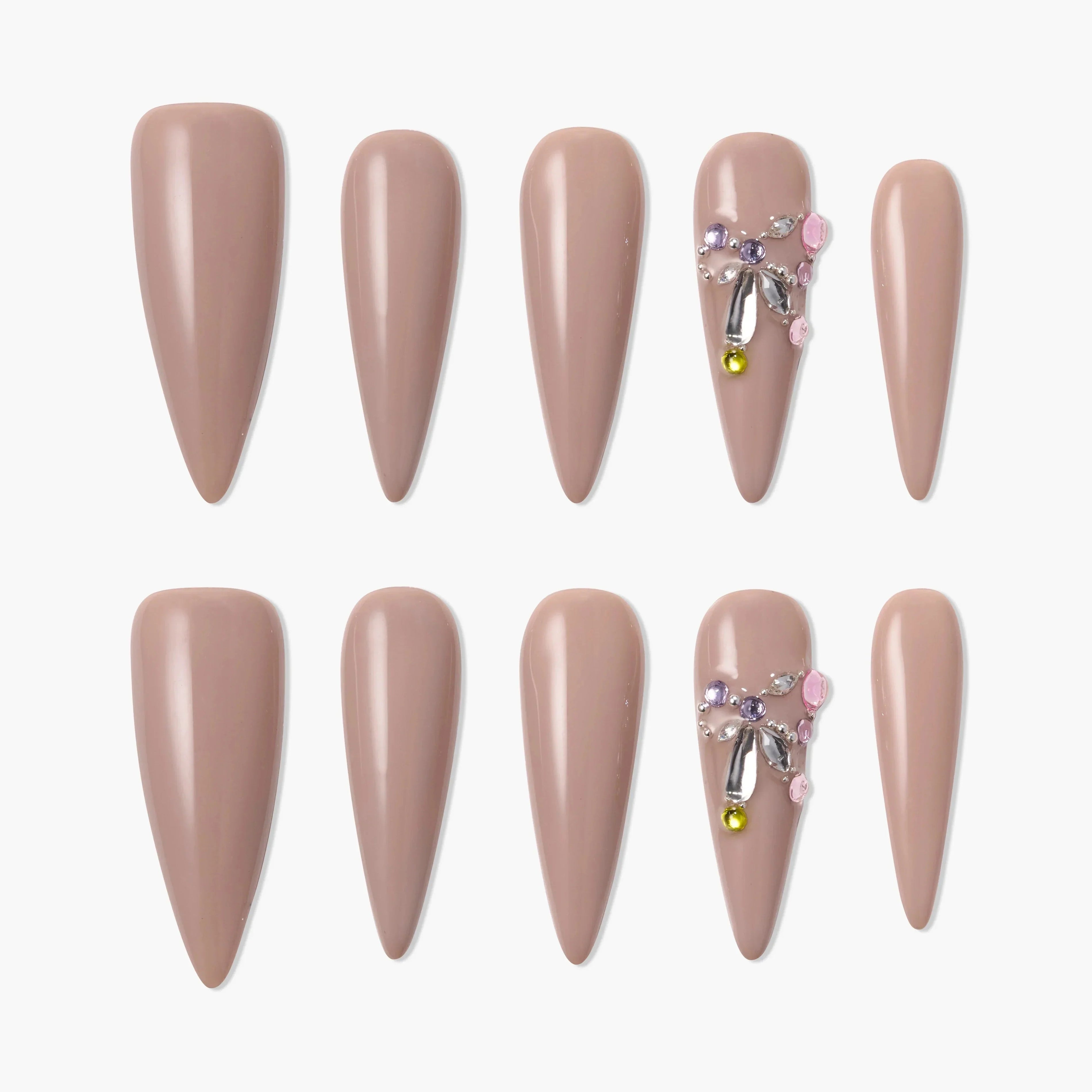 Almond-shaped nude press-on nails set with rhinestone and gem accents on two nails