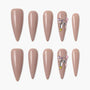 Almond-shaped nude press-on nails set with rhinestone and gem accents on two nails