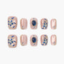Pink handmade press-on nails with blue floral designs and gemstone accents, set of ten.