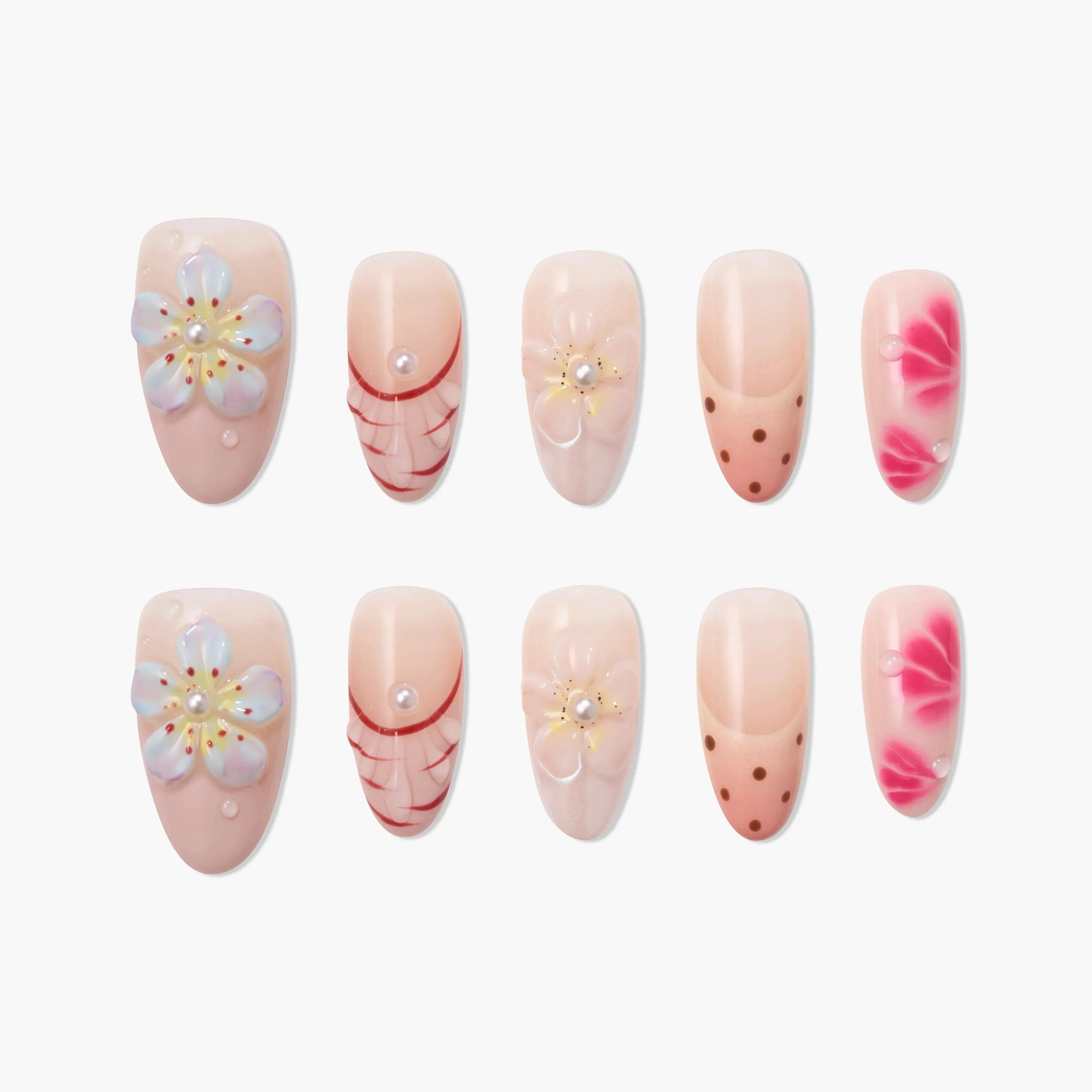 Handmade press-on nails with pink floral, polka dot, and pearl accent designs