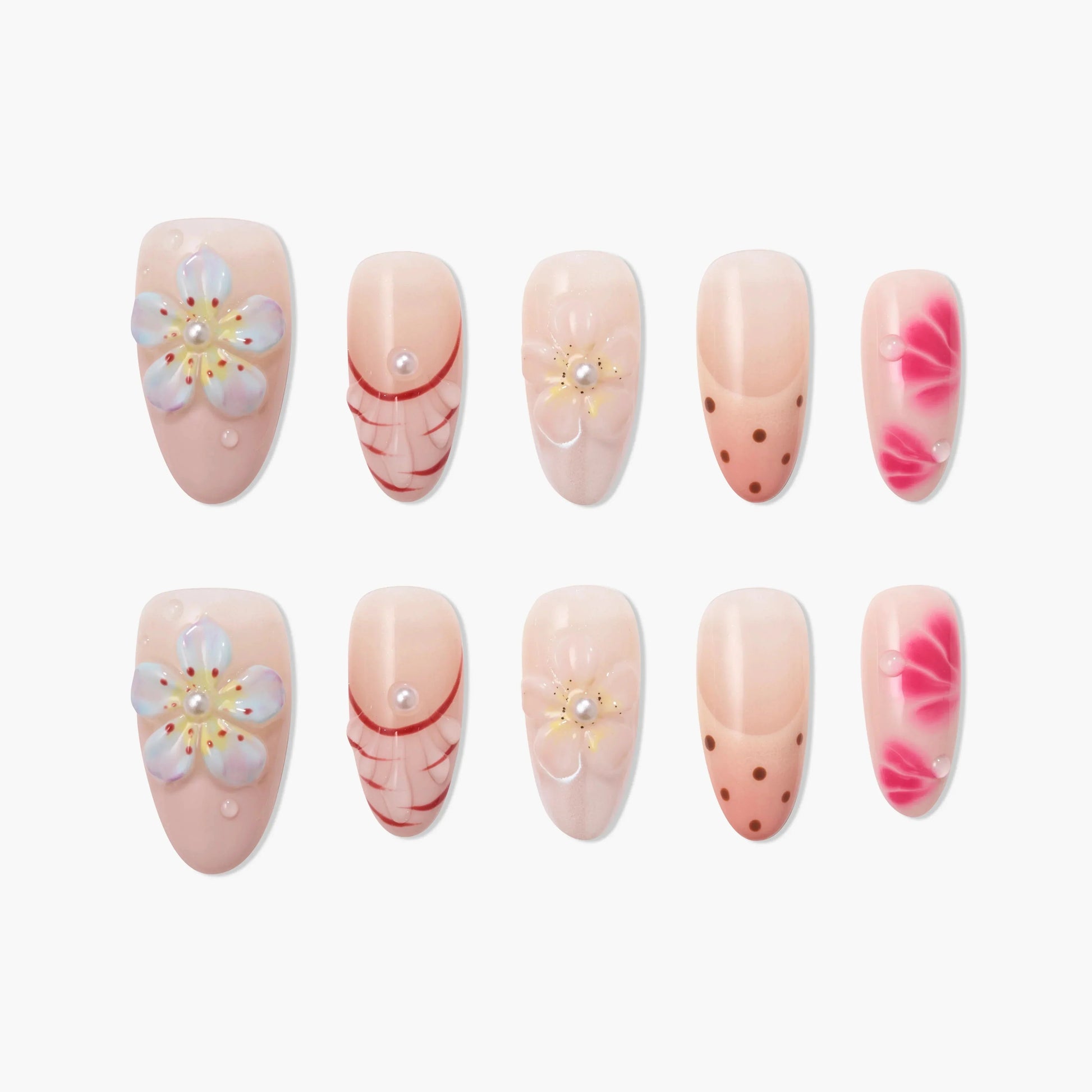 Handmade press-on nails with pink floral, polka dot, and pearl accent designs