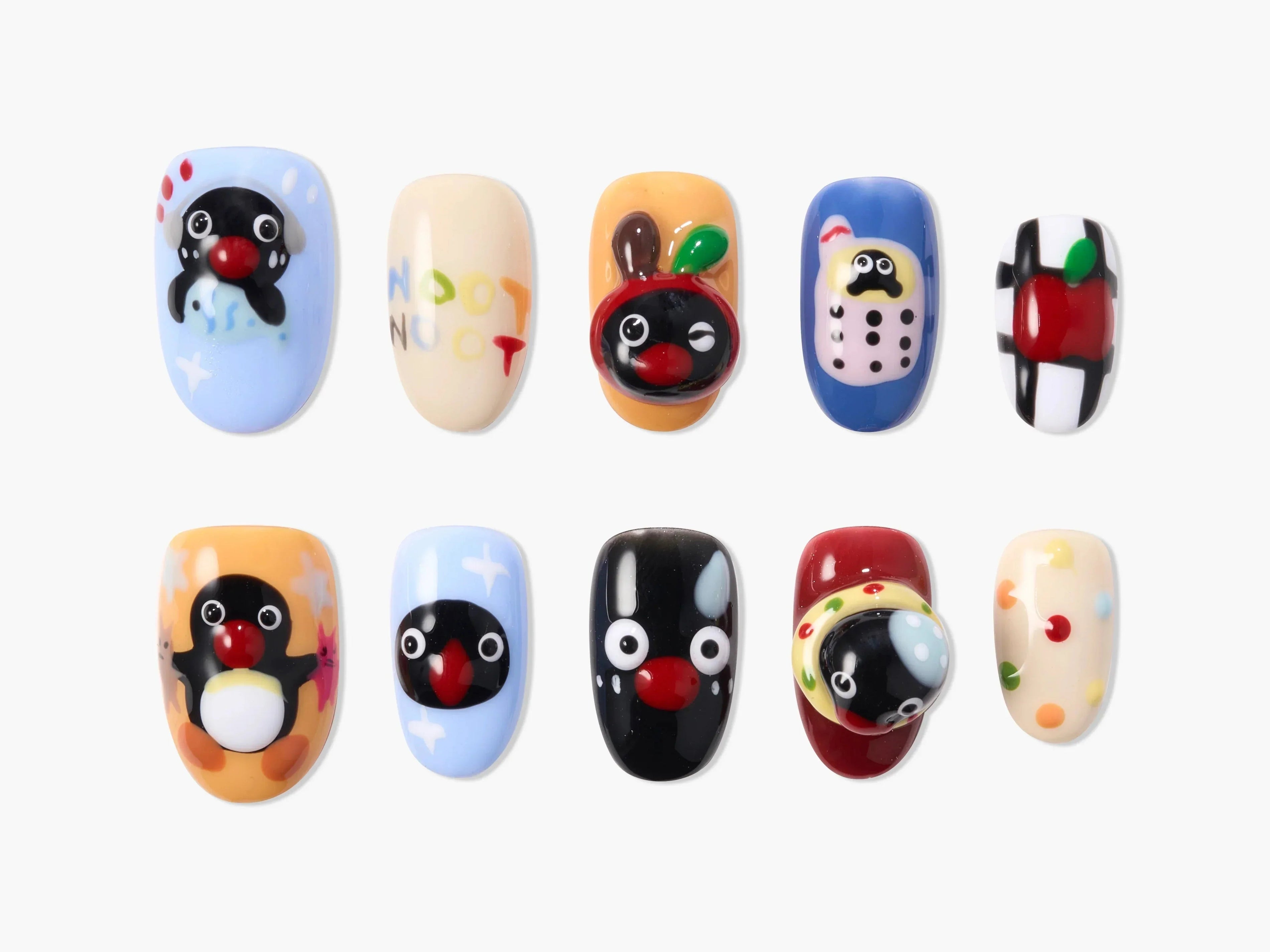 Handmade press-on nails with colorful cartoon designs, penguins, apples, and playful art
